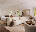 Modern bedroom with white sofa, wooden coffee table, and large windows.