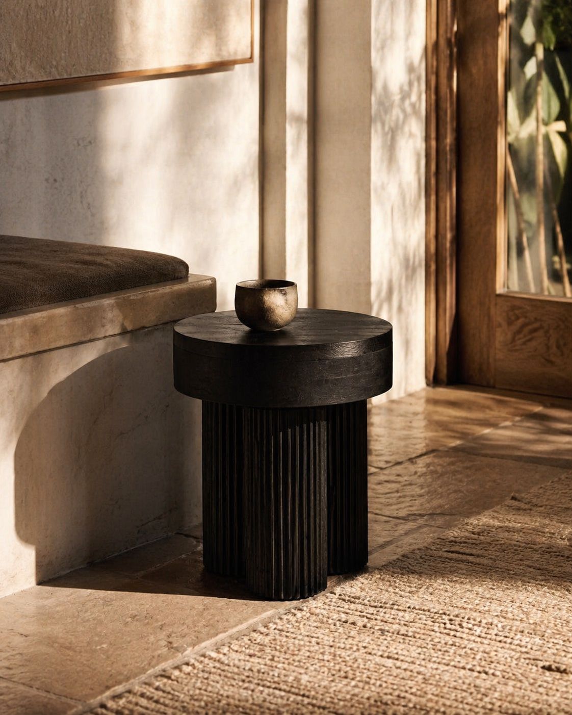 Dark wooden side table with a small decorative object in a softly lit room.