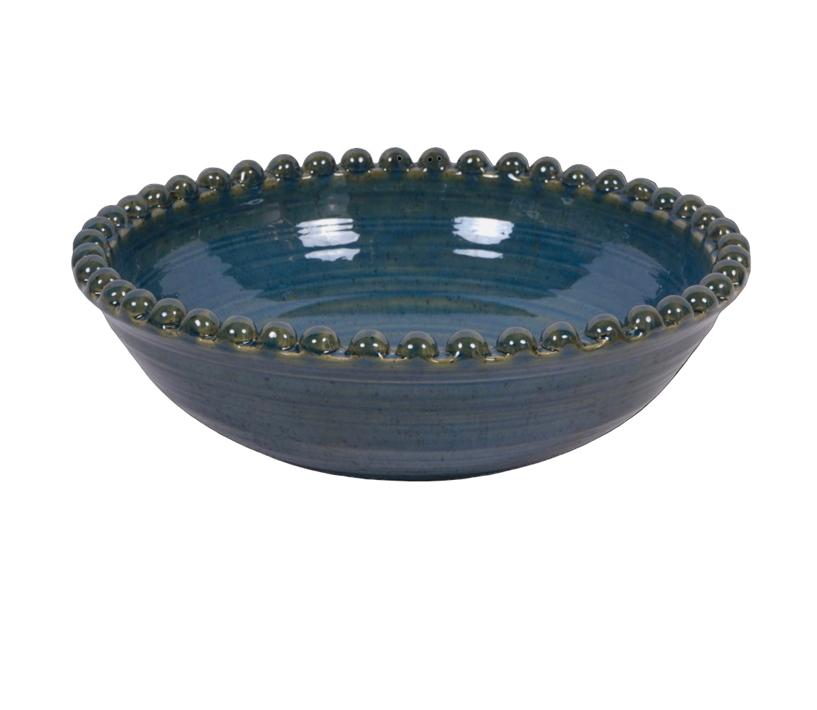 Blue ceramic bowl with bead-like rim on a white background
