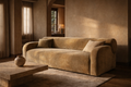 Neutral Ccontemporary sofa in a room with a square coffee table and organic decorative elements.