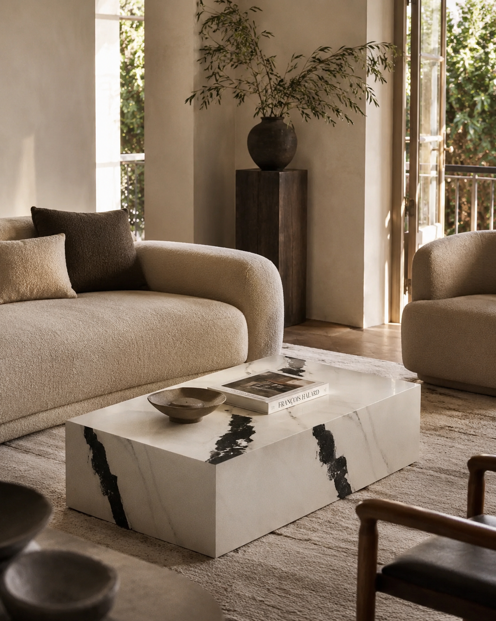 Modern living room with beige sofa, marble coffee table, and decorative elements.