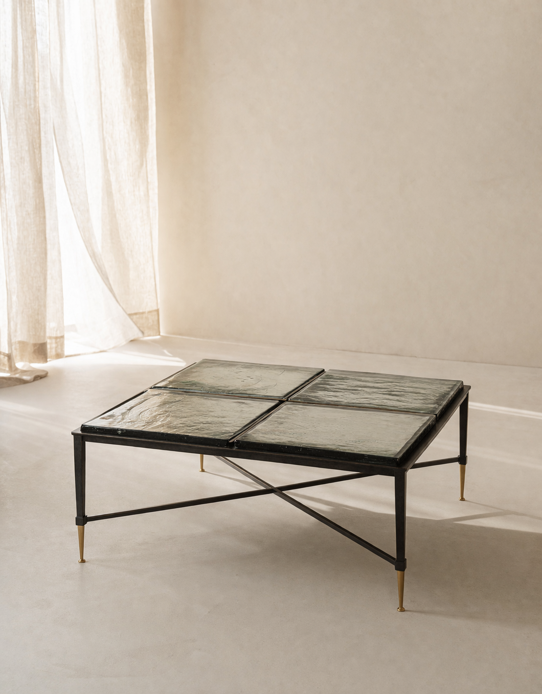 Modern coffee table with glass top and metal frame in a minimalistic room.