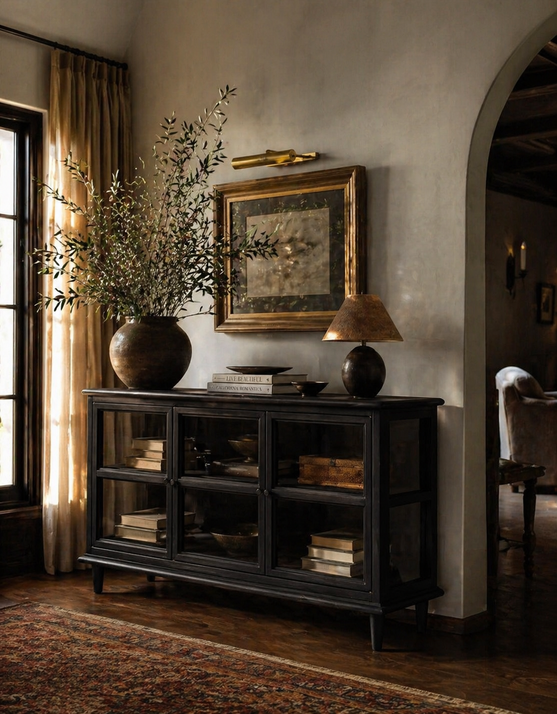 Dark wooden sideboard with decorative items in a room with a large mirror and lamp.